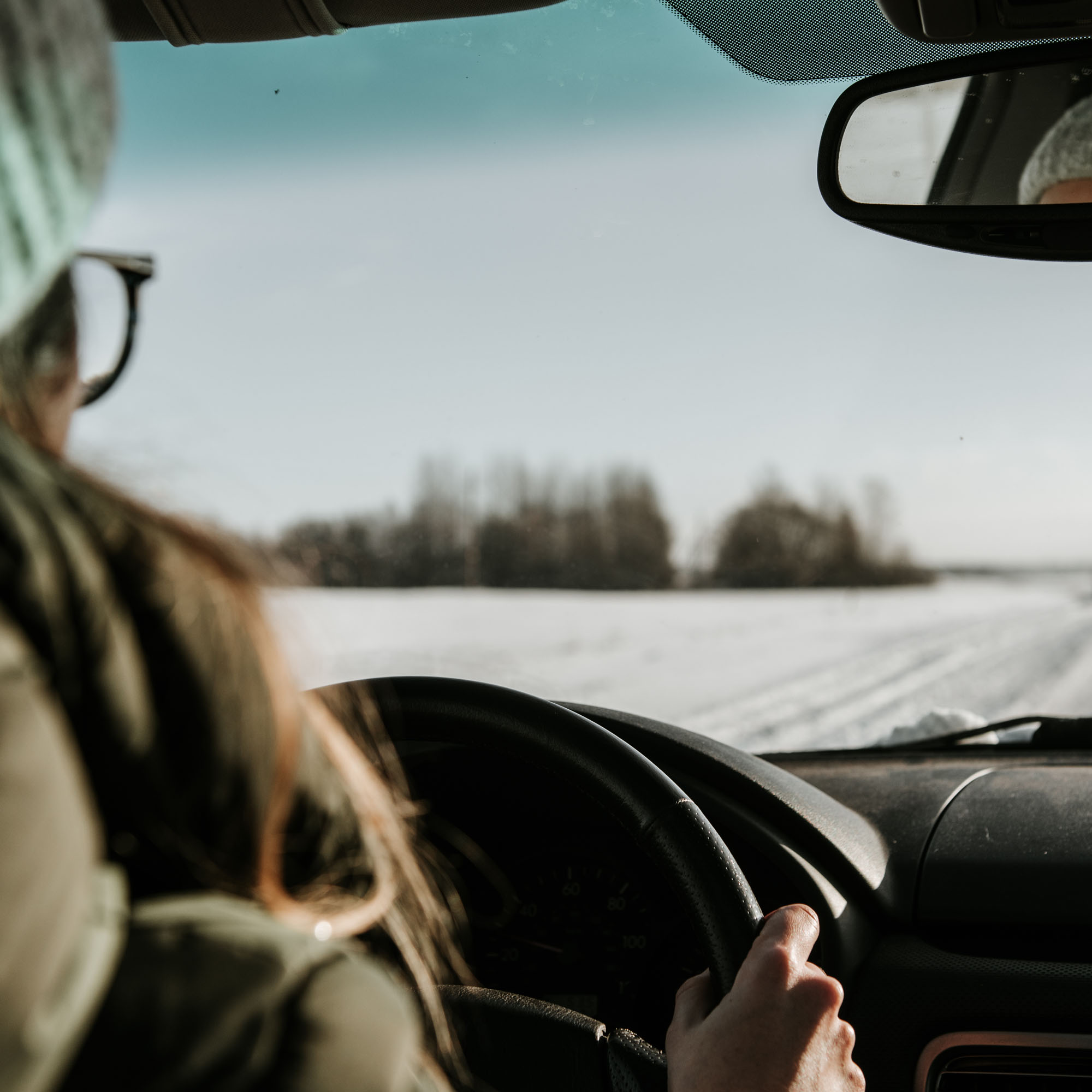 Woman driving during winter with ice and snow on the road